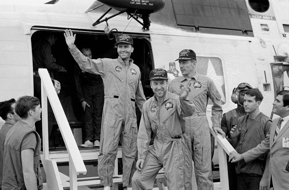 S70-35614 (17 April 1970) --- The crewmembers of the Apollo 13 mission, step aboard the USS Iwo Jima, prime recovery ship for the mission, following splashdown and recovery operations in the South Pacific Ocean. Exiting the helicopter which made the pick-up some four miles from the Iwo Jima are (from left) astronauts Fred W. Haise Jr., lunar module pilot; James A. Lovell Jr., commander; and John L. Swigert Jr., command module pilot. The crippled Apollo 13 spacecraft splashed down at 12:07:44 p.m. (CST), April 17, 1970.<br />Credits: NASA
